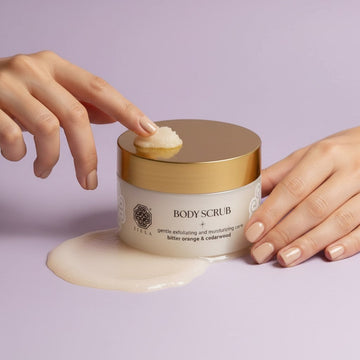 Assemble K - Play .Try .Glow Tiela body scrub jar with gold lid, featuring gentle exfoliating and moisturizing care with bitter orange & cedarwood scent.