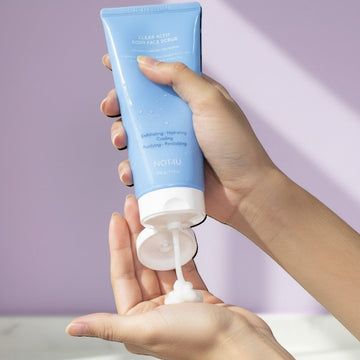 Assemble K - Play .Try .Glow NOT4U Clear Acfit Body Pack Scrub 220g, a light blue tube dispensing white scrub onto a hand.