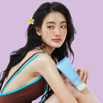 Assemble K - Play .Try .Glow NOT4U Clear Acfit Body Pack Scrub 220g, a light blue tube dispensing white scrub onto a hand.