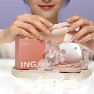 Assemble K - Play .Try .Glow INGA Water Glow Daily Cushion in 21N Light Beige, presented with delicate pink and white flowers.