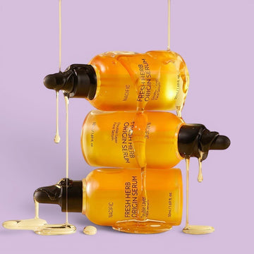 Assemble K - Play .Try .Glow Nacific Fresh Herb Origin Serum, a double-layer face serum in a clear bottle with a black dropper, featuring a golden liquid and citrus accents.
