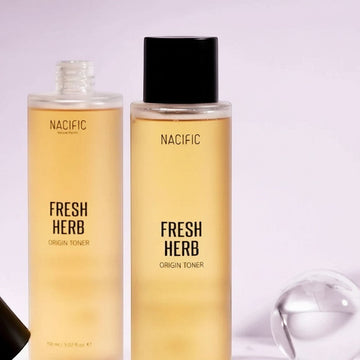Assemble K - Play .Try .Glow NACIFIC Fresh Herb Origin Toner, a golden-hued liquid in a clear bottle with a black cap, designed to soothe and nourish skin.