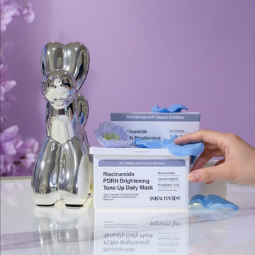 Assemble K - Play .Try .Glow Niacinamide PDRN Brightening Tone-Up Daily Mask with hyaluronic acid and centella blend on a reflective surface.