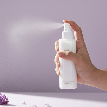 Assemble K - Play .Try .Glow NOT4U Moisture Cream Body Mist in a white spray bottle held by a hand.