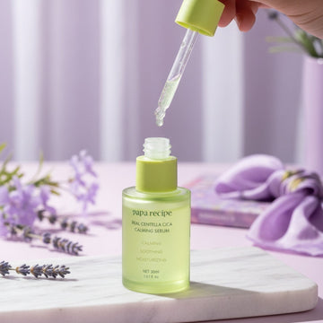 Assemble K - Play .Try .Glow: Papa Recipe Real Centella Cica Calming Serum in a green glass bottle with a dropper, featuring calming, soothing, and moisturizing properties.
