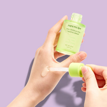 Assemble K - Play .Try .Glow: Papa Recipe Real Centella Cica Calming Serum in a green glass bottle with a dropper, featuring calming, soothing, and moisturizing properties.