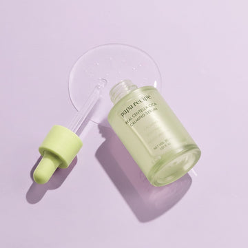 Assemble K - Play .Try .Glow Papa Recipe Real Centella Cica Calming Serum 30ml, a light green glass bottle with a dropper, on a pastel green background.