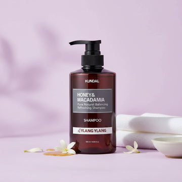 Assemble K - Play .Try .Glow KUNDAL Honey & Macadamia Ylang Ylang Shampoo 500ml, a dark amber bottle with a black pump dispenser.