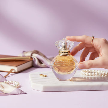 Assemble K - Play .Try .Glow Marina De Bourbon Golden Dynastie perfume bottle on a marble tray with pearls and a notebook.