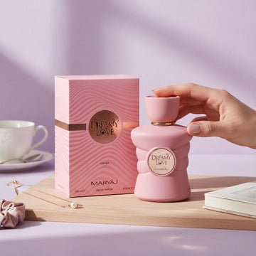 Assemble K - Play .Try .Glow Maryaj Dreamy Love eau de parfum bottle and box on a wooden tray with a hand reaching out.