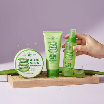 Assemble K - Play .Try .Glow NATURE REPUBLIC aloe vera soothing gel and mist set on a wooden board with fresh aloe leaves