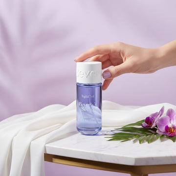 Assemble K - Play .Try .Glow Beverly's Secret Tropical Thrill perfume bottle on a marble table with flowers