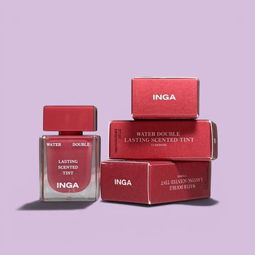 Assemble K - Play .Try .Glow Inga Water Double Lasting Scented Tint in Tuberose shade, a red lip tint with a clear applicator and red cap, presented with its packaging.