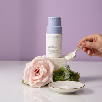 Assemble K - Play .Try .Glow VELY VELY Enzyme Milk Powder Cleanser in a white bottle with a lavender cap, featuring a pink rose and green moss.
