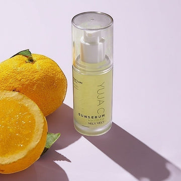 Assemble K - Play .Try .Glow VELY VELY Yuja C Sun Serum 30ml bottle with fresh yuzu fruit slices.