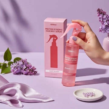 Assemble K - Play .Try .Glow Kundal Protein Bonding Hair Mist Serum in Violet Muguet scent, a pink spray bottle with a box.